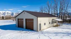 White metal garage with lean-to and mountain view in winter