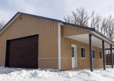 24x30 steel maintenance shop with front porch in snowy landscape