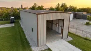 Tan and brown metal garage workshop with open bay at sunset.
